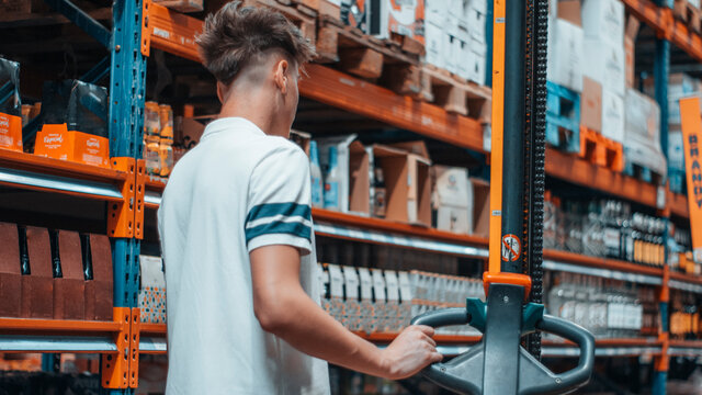Hombre joven encargado en un almacen revisando las maquinas del comercio