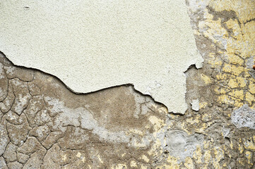Old concrete wall with peeling plaster and cracks