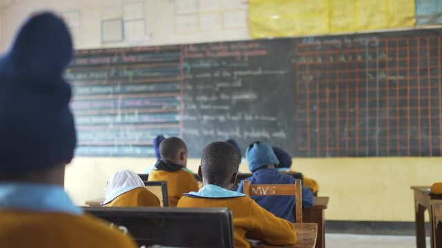 African school with children doing class looking the blackboard. Tanzania, Africa 4K.