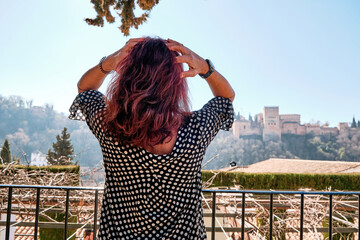 lifestyle portrait of young beautiful and relaxed woman having vacation with Alhambra in background...