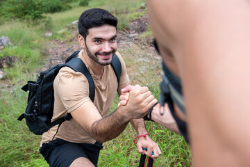 two of them reached out to help each other on the way up the mountain.,friends helping hands,concept mutual assistance