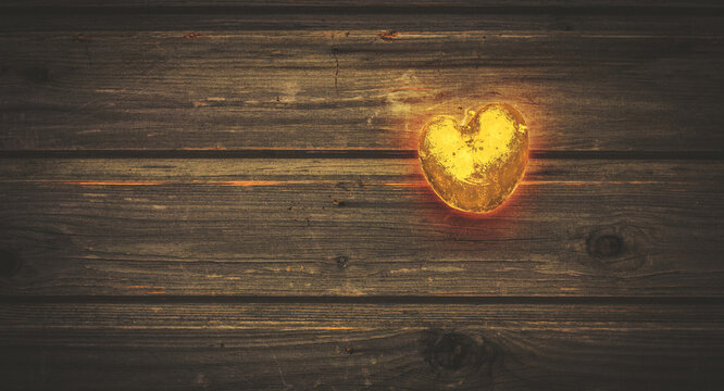 Red-hot golden heart burns and shines on a brown wooden vintage table in rustic style, metallic, valentines day, wooden background, country style