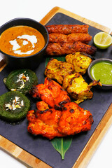 indian food speciality tandoori mix platter, includes chicken tikka, lamb seekh kebab, fish tikka, hara bhara kabab, dal makhani and breads - obrazy, fototapety, plakaty