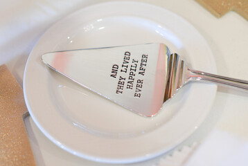 Silver cake serving utensil engraved with the phrase 