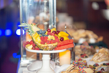 Assorted fruit platter with pineaple, watermelon, cherries, berries, blueberries and stawberries at desset bar