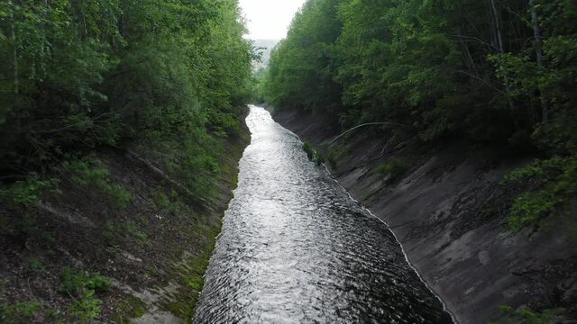 Drone view of an artificial canal in a green forest