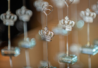 Silver table number place card holers in the shape of kings crowns and hearts