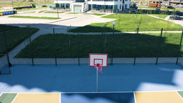 Aerial view on a kid with a basketball ball. Boy practicing shooting a basketball.
