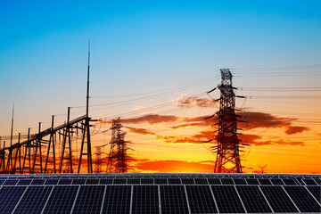 Solar panels and high voltage towers in the evening
