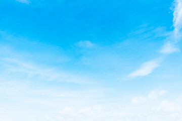 The blue sky is tinged with white clouds in the air on a bright summer day.