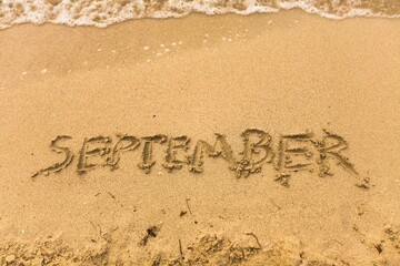 Fototapeta premium Inscription on wet sand september beach.