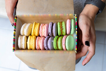 Multicolored sweet macaroons or macaroon flavored cookies in a paper box