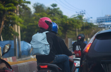 motorcycle passenger with safety helmet same as rider on street road traffic view in Bangkok asia Thailand