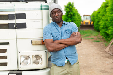 African-American posing near truck during summer day