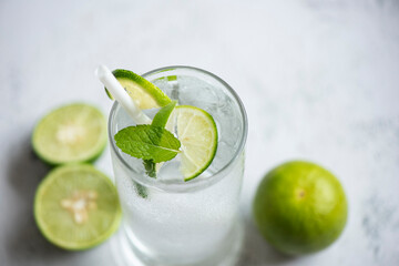 Fototapeta premium Summer drink juicy lime slice top view, Exotic summer drinks refreshing of cold drinks glasses fresh fruit on ice homemade cocktail tea with mojito lemon lime and mint leaf