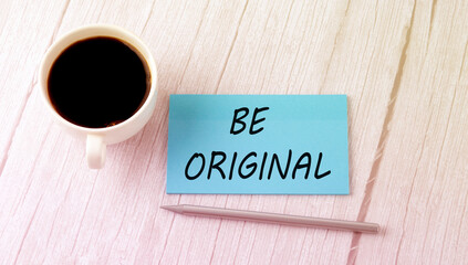 BE ORIGINAL text on the blue sticker with cofee and pen