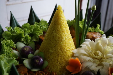Cone-shaped yellow rice is an Indonesian traditional food, called Nasi Tumapeng. A lively Indonesian rice dish with side dishes.