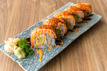 California salmon sushi rolls stuffed with salmon, avocado, topping salmon roe and spicy cream sauce. Japanese food style