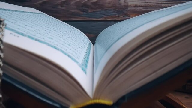 Islamic concept - The Holy Al Quran with written Arabic calligraphy meaning of Al Quran and a beautiful Arabian lamp, Arabic word translation: The Holy Al Quran (holy book of Muslim)