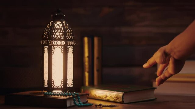 Islamic concept - The Holy Al Quran with written Arabic calligraphy meaning of Al Quran and a beautiful Arabian lamp, Arabic word translation: The Holy Al Quran (holy book of Muslim)