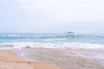 Waves crashing onto a sandy beach.