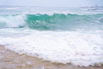 Waves crashing onto a sandy beach.
