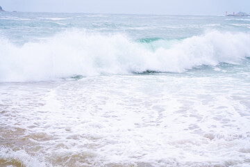Waves crashing onto a sandy beach.