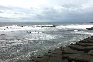 People who surf while the waves are rushing to the coast of Shonan where the typhoon is approaching