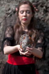 Naklejka premium beautiful girl, brunette in a black dress with a red belt, photo session in the mountains, altai, red lips