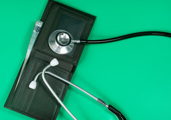 Medical and business concept. Layout of stethoscope and wallet with cash reference to medical bills. Selective focus points