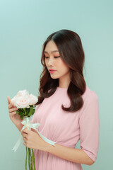 Young woman with beautiful bouquet on light background,