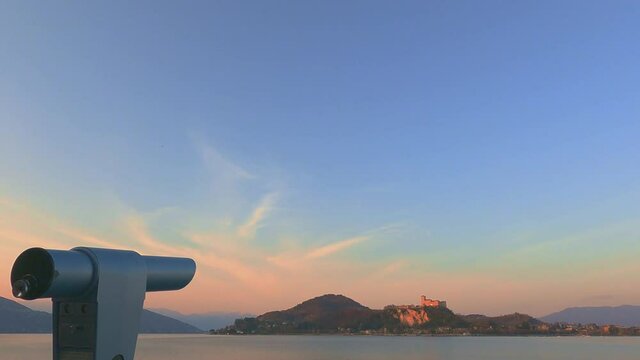 Binocular for observation Angera castle on Maggiore lake in Italy from Arona viewpoint at sunset