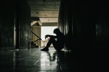 Dramatic, Silhouette of Sad Depressed man sitting head in hands on the floor. Sad man, Cry, drama, lonely and unhappy concept..