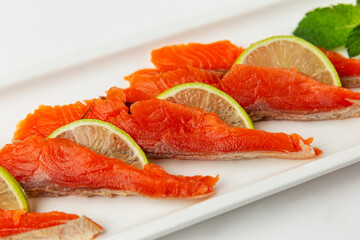 Sliced red fish with lemon on a plate. Appetizing appetizer. Vitamins and healthy food. Close-up.