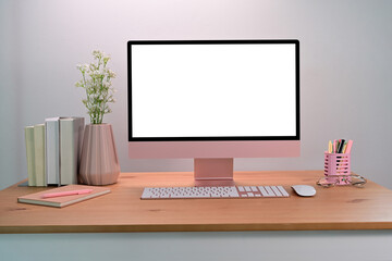 Computer with blank screen on wooden table. Female workspace.