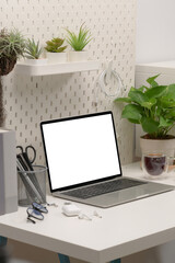 Fototapeta premium Comfortable workplace with laptop computer and houseplant.