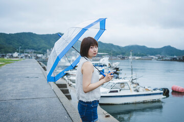 Obraz premium 雨の日の海にいる女性