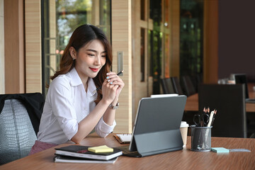 Businesswoman reading news on computer tablet.