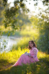 beautiful girl in a vintage rose dress walks by the lake with a white fluffy rabbit © AKaltykova