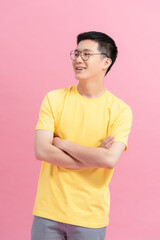 Obraz premium Asian young handsome man in yellow t-shirt smiling on pink background