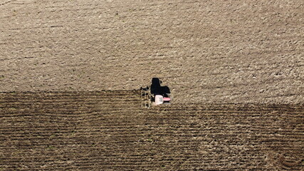 top down drone view of an old red tractor tilling a large field in preparation for planting a crop on a farm in regional New South Wales Australia © fieldofvision