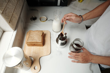 Man making Vietnamese style coffee and sandwiches for breakfast, view from the top