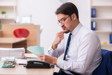 Young male bookkeeper in budget planning concept