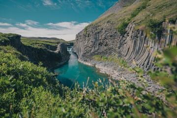 Overview of Studlagil canyon in Iceland, picturesque valley with basalt columns standing high on a...