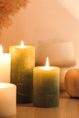 Fototapeta na wymiar Burning candles on table in room, closeup