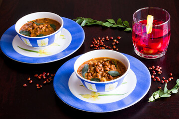 Black-eyed Pea also called Red Lobiya or Lobhiya in India,is a gravy dish,has tomatoes and curry leaves.Served with local fruit punch called Kokum. Front view,closeup,dark background, side lit