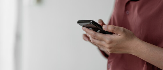 Women's hands use a smartphone for online shopping, social networking, or remote work. Close up image