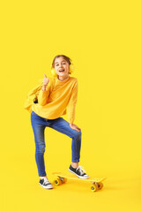 Happy little girl listening to music on color background