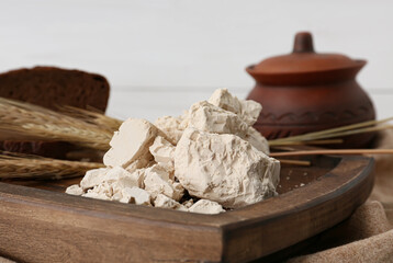 Wooden board with fresh yeast on table