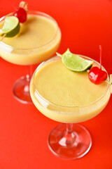Glasses of tasty banana daiquiri cocktail on color background